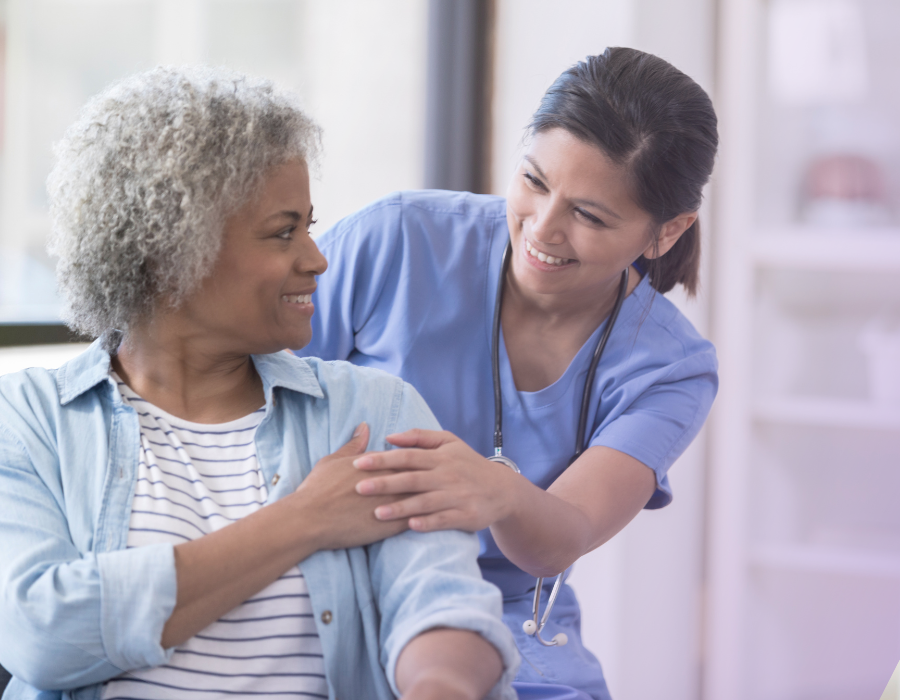 Nurse smiling with patient, holding hands